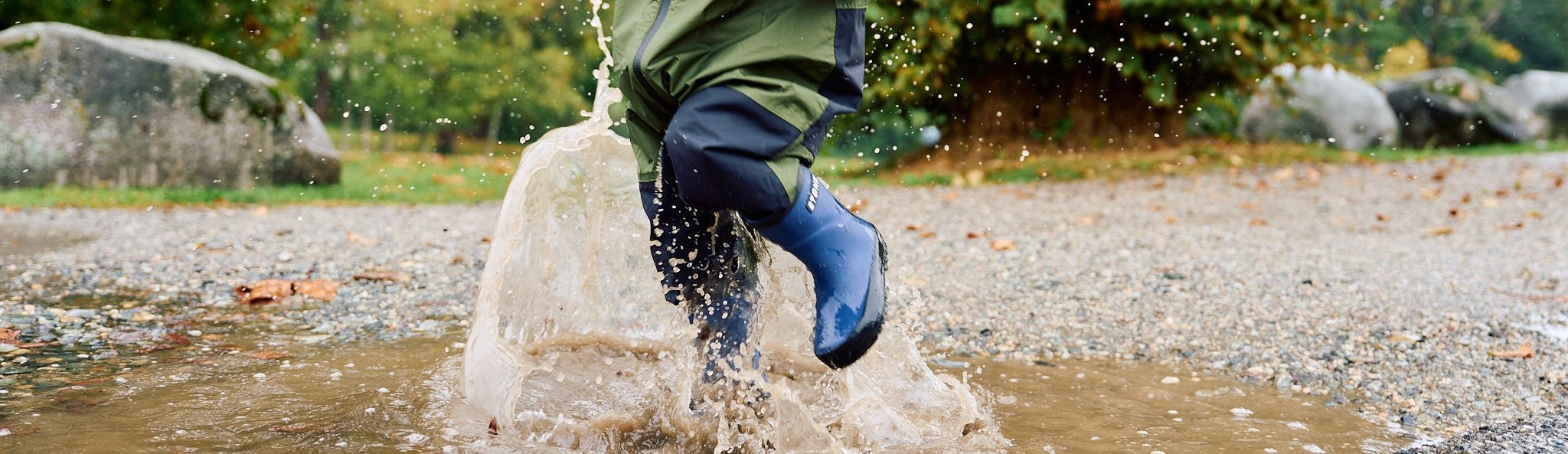 Girl walking on a big puddle wearing the cypress natural rubber rain boots