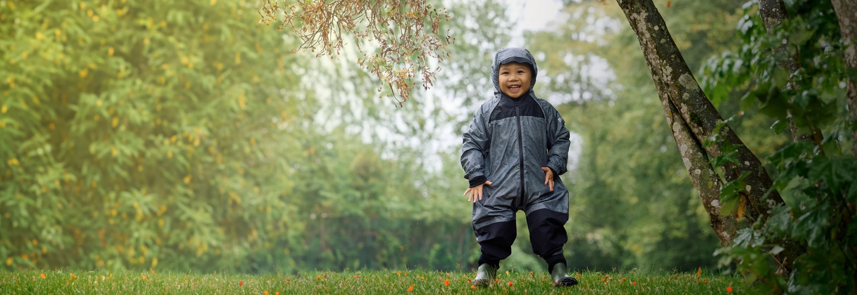 A cute little kid in stonz rain suit cypress colour and a bucket hat. very durable and waterproof rain suit.