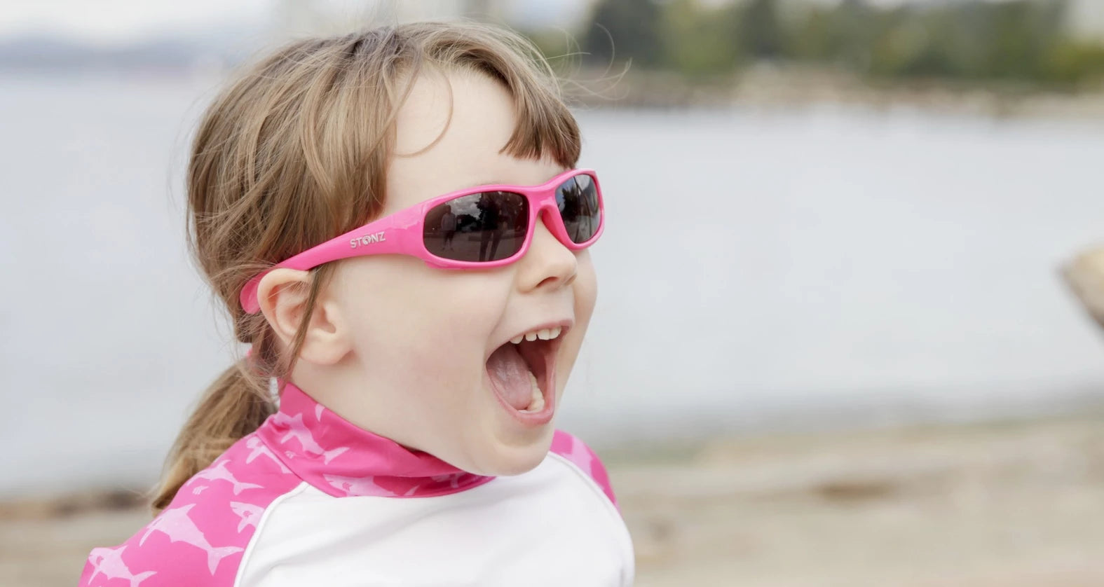 A cute kid with stonz sport sunnies at the beach