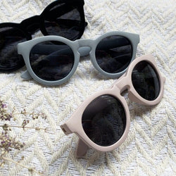 Stonz Eco Sunnies in Black, Haze Blue, and Haze Pink, laid out on a white blanket.