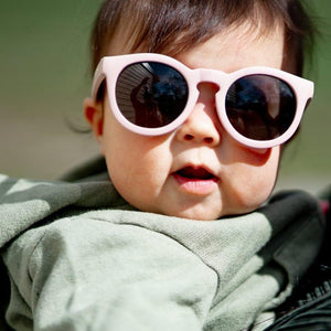 Stonz Eco Sunnies in Haze Pink, shown close up on a child.