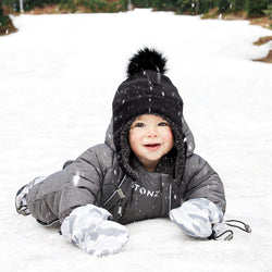 Stonz Baby Mitts in Camo Print - Light Grey, worn by an infant laying in the snow.